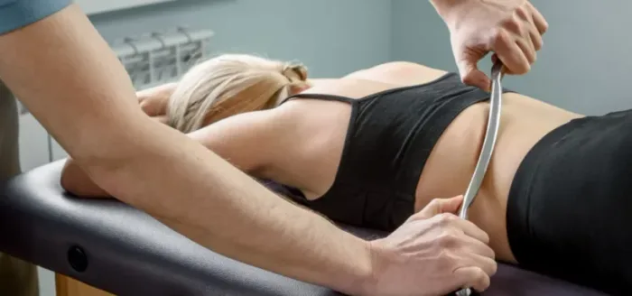Physical therapist using a soft-tissue instrument during a treatment session at Miccass Physical Therapy in New York, NY