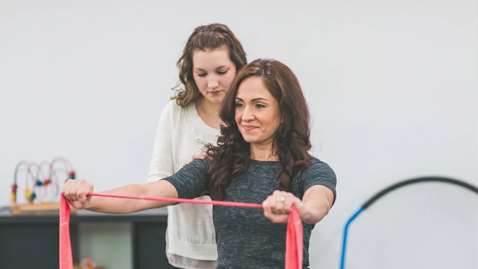 Physical therapist guiding a patient through a resistance band exercise