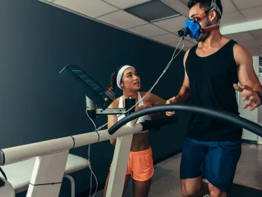 Runner being evaluated on a treadmill with metabolic testing equipment